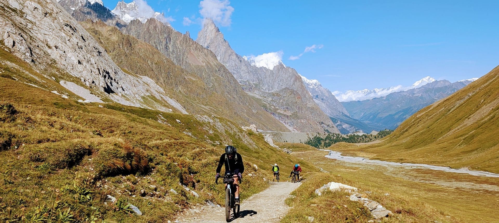 Gravel Tour du Mont Blanc – Montée au col de la Seigne Vélo, VTT, Gravel en montagne sur le tour du Mont Blanc, au fond l'Aiguille noire de Peuterey