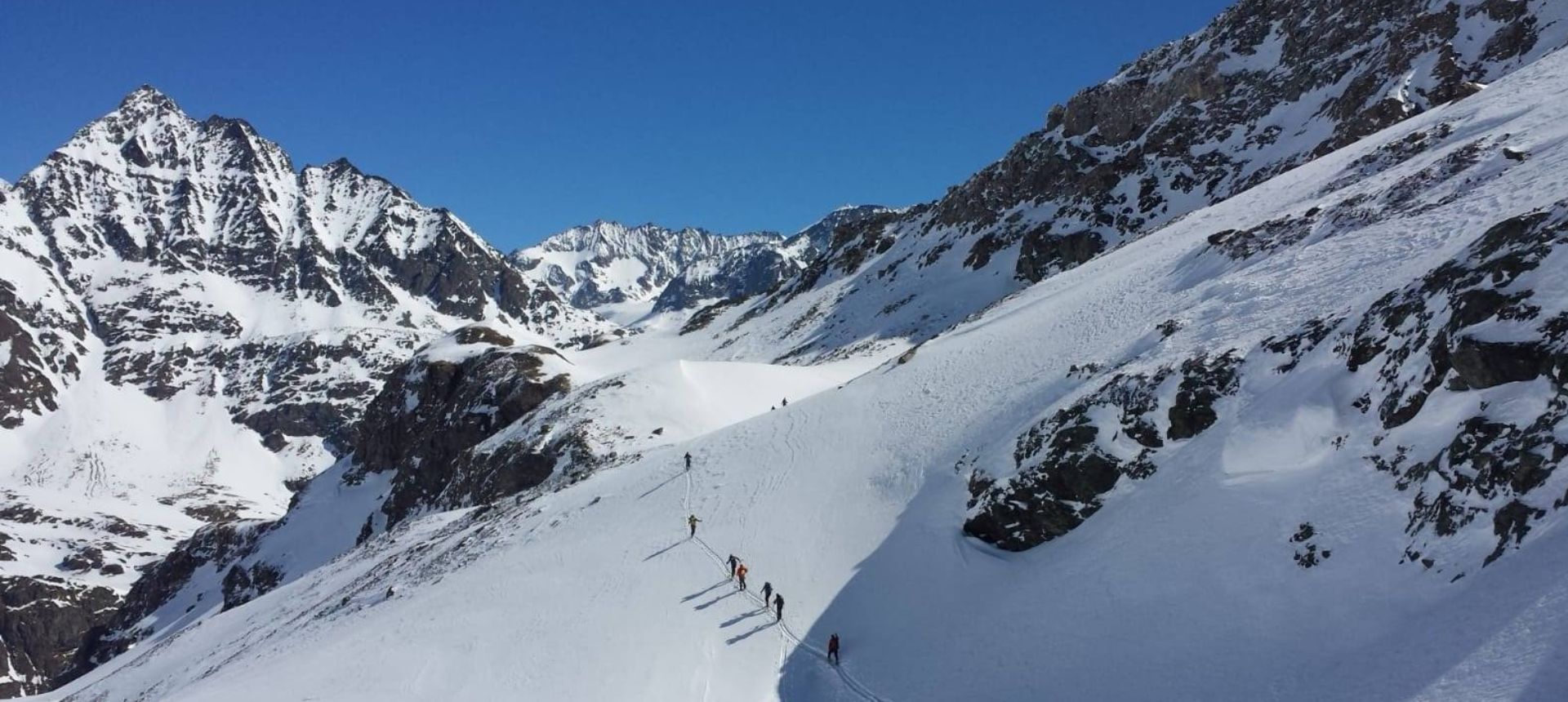 Un groupe de skieurs de randonnée dans une ambiance très haute montagne