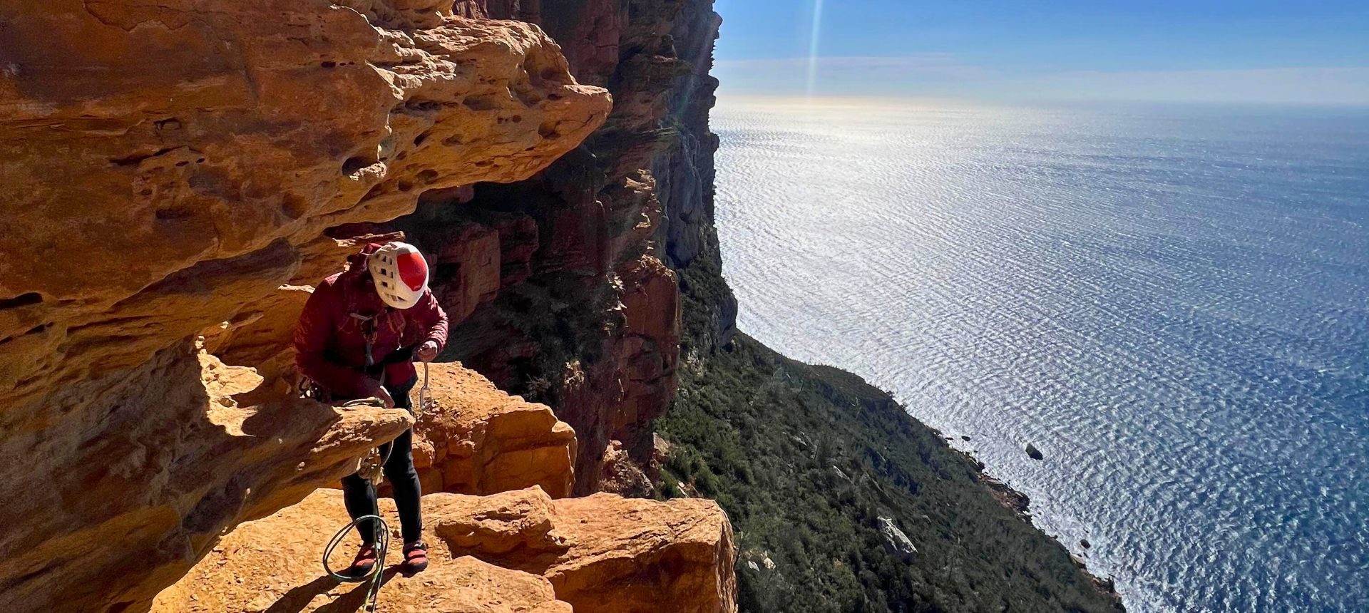 Calanques – une vire pour un parcours unique au-dessus de la Méditerranée Femme sur un via corda sur une vire surplombanb la mer