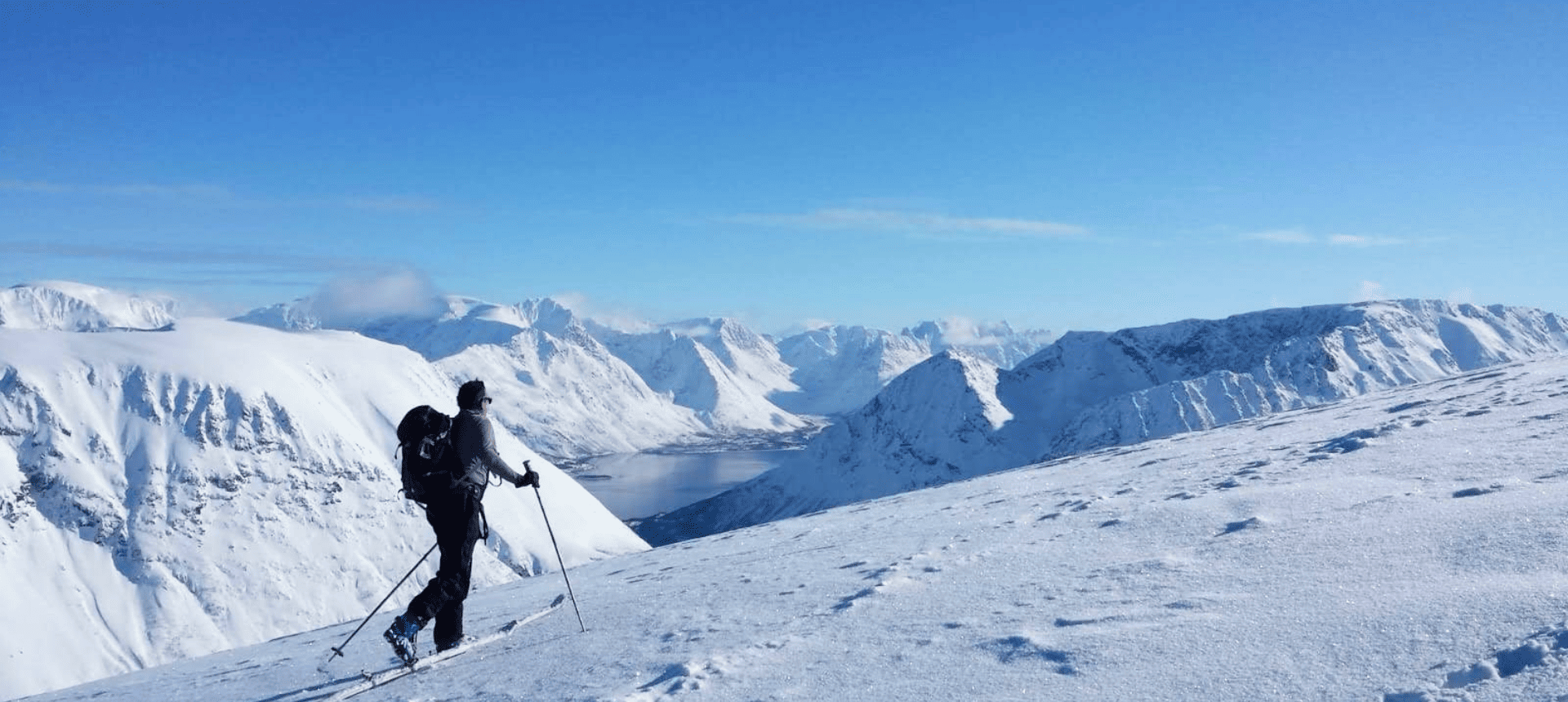 Header Randonnée à ski dans les Alpes Norvégienne Skieur de randonnée en hiver dans les montagnes au-dessus de la mer