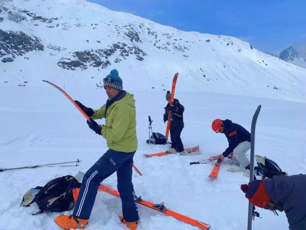 Skieurs se préparant à la montée en installant des "peaux de phoques" ou peluches autocollante
