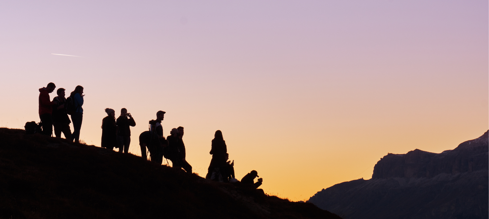 un groupe se retrouve au sommet de la montagne pour le coucher de soleil