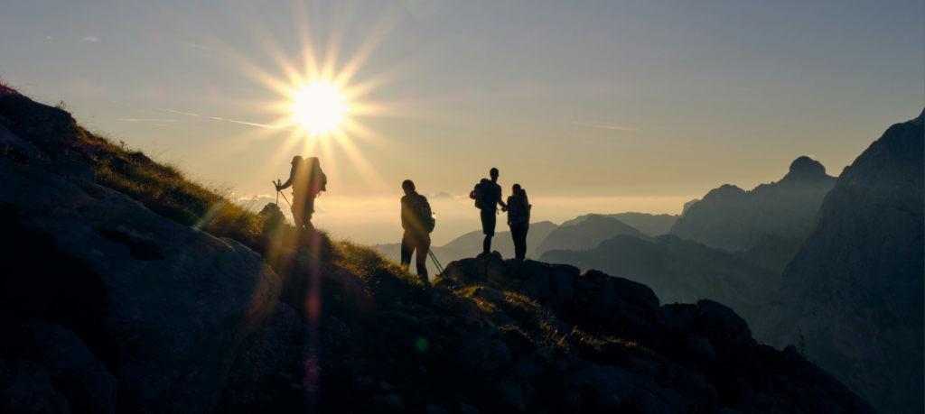 4 fast hikers arrivent au sommet au soleil couchant