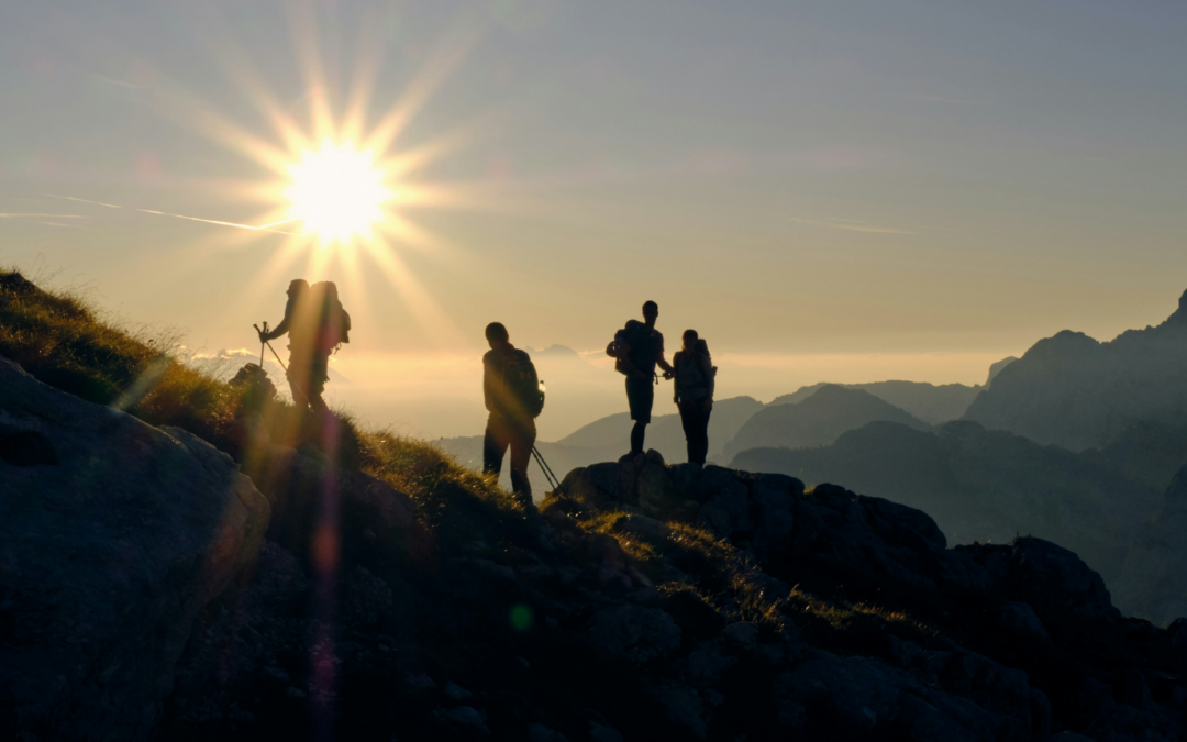 4 fast hikers arrivent au sommet au soleil couchant