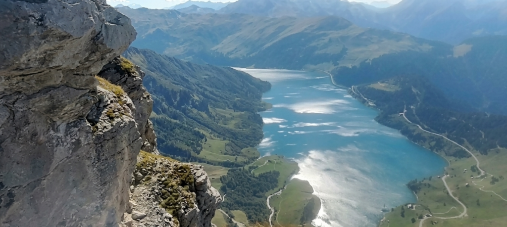 vue-roselend-roc-des-vents©We-Rando vue panoramique sur les eaux scintillates du lac de Roselend depuis le Roc des vents dans le Beauforatain
