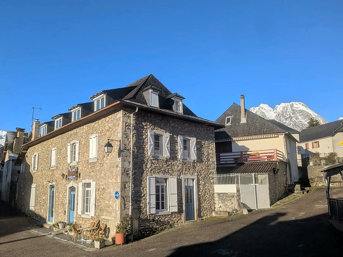 lescun-gite-montagne©gite-pic-danie Gîte en pierre aux volets blancs et toit d'ardoise dans le village de Lescun, au pied des sommets enneigés sous un ciel bleu