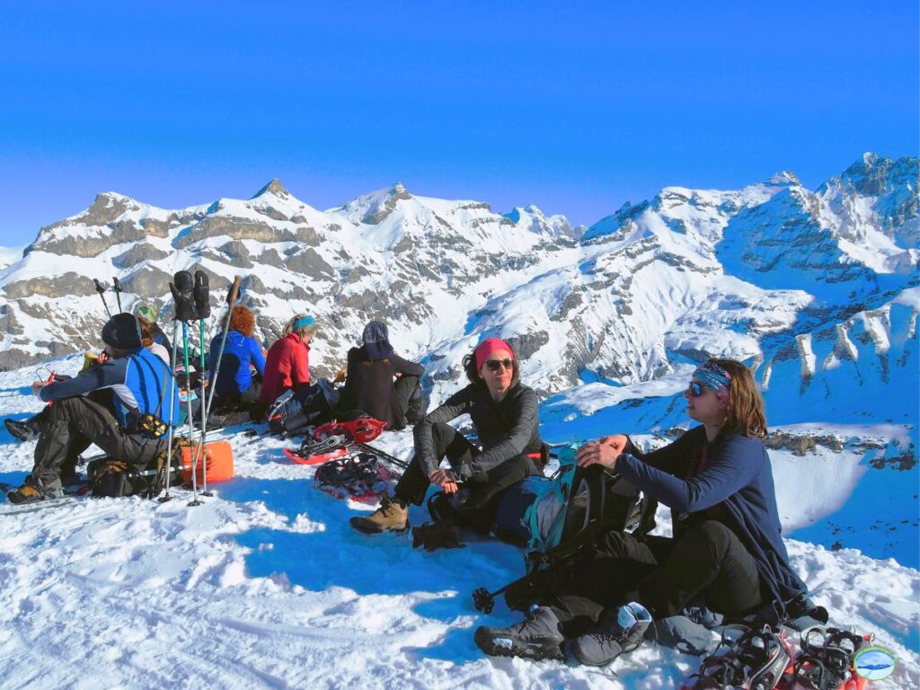 randonneurs en raquettes sur un sommet des alpes bernoises